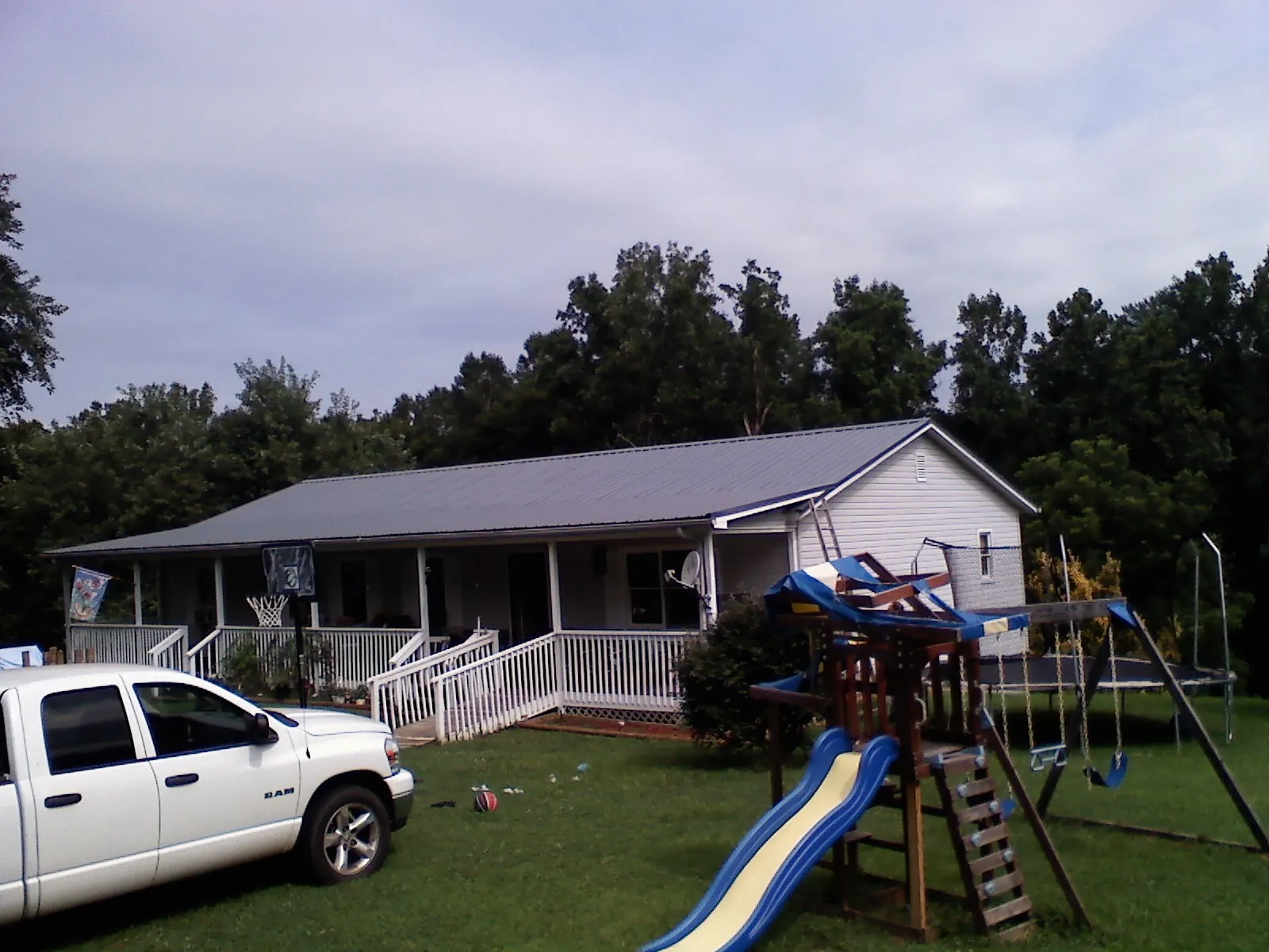 Dark metal roof on a country home with a full length front porch in Lake City